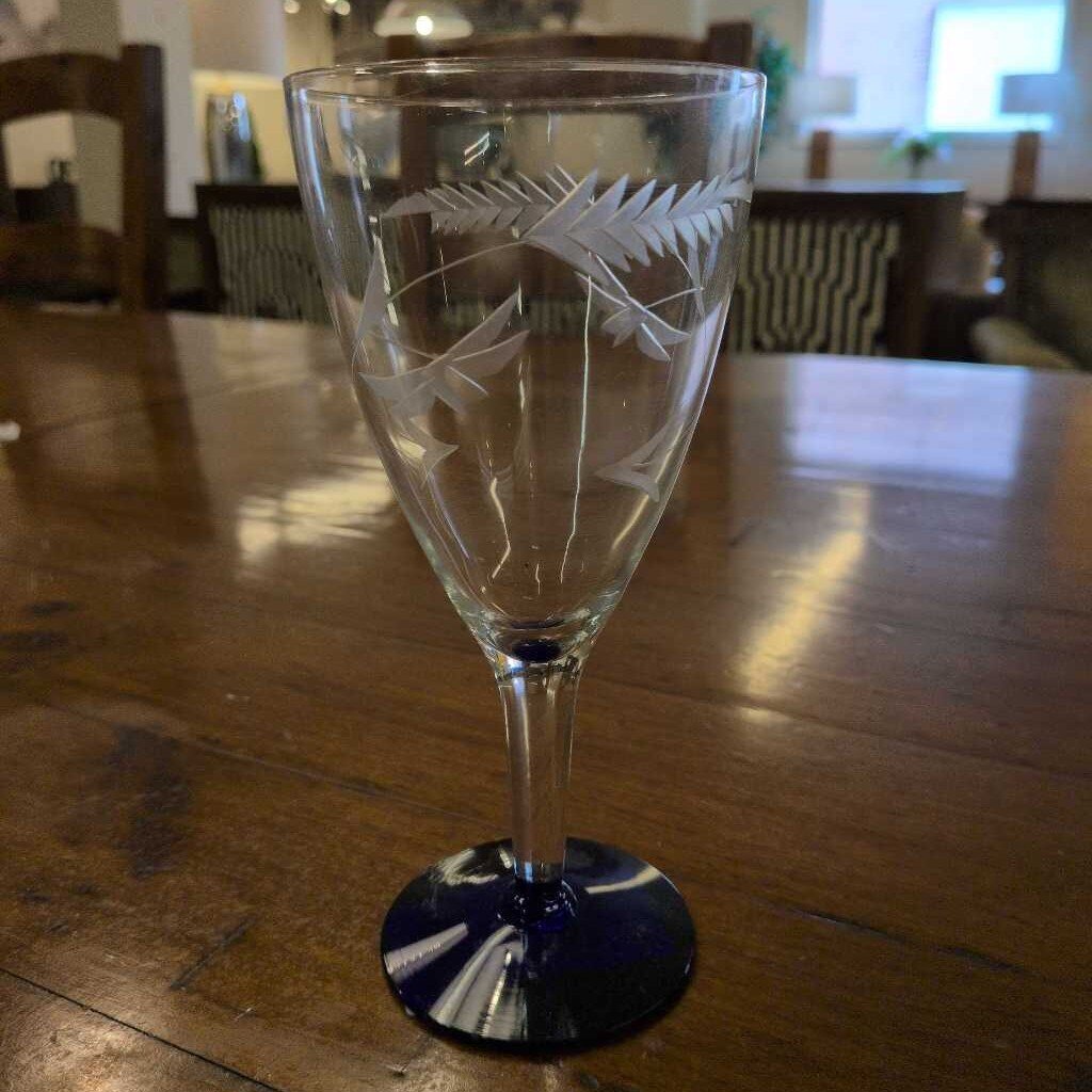 Etched glass goblet on a wooden table with a blurred background