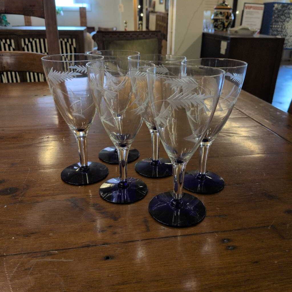 Set of six etched wine glasses on a wooden table