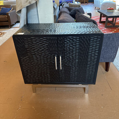 Black woven side table in a room with furniture and decor
