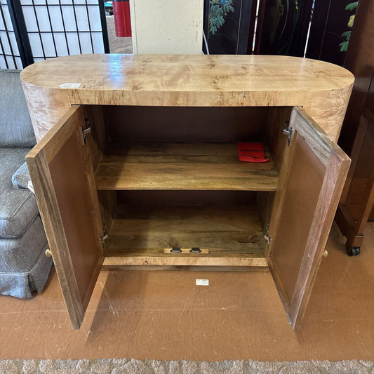 Wooden cabinet with open doors on a cardboard surface