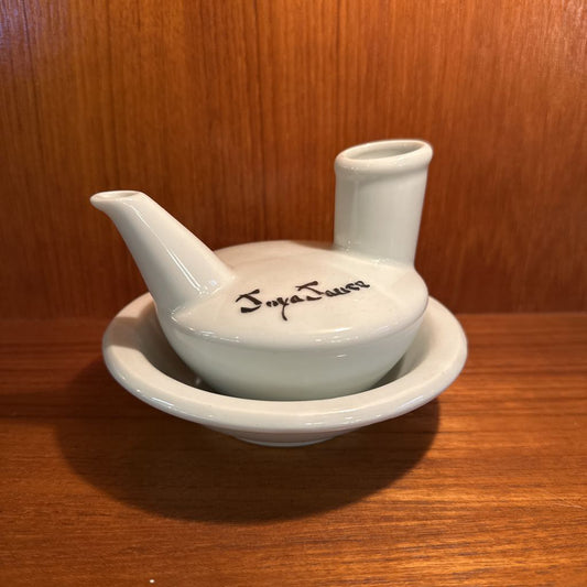 White ceramic container with a lid on a wooden surface