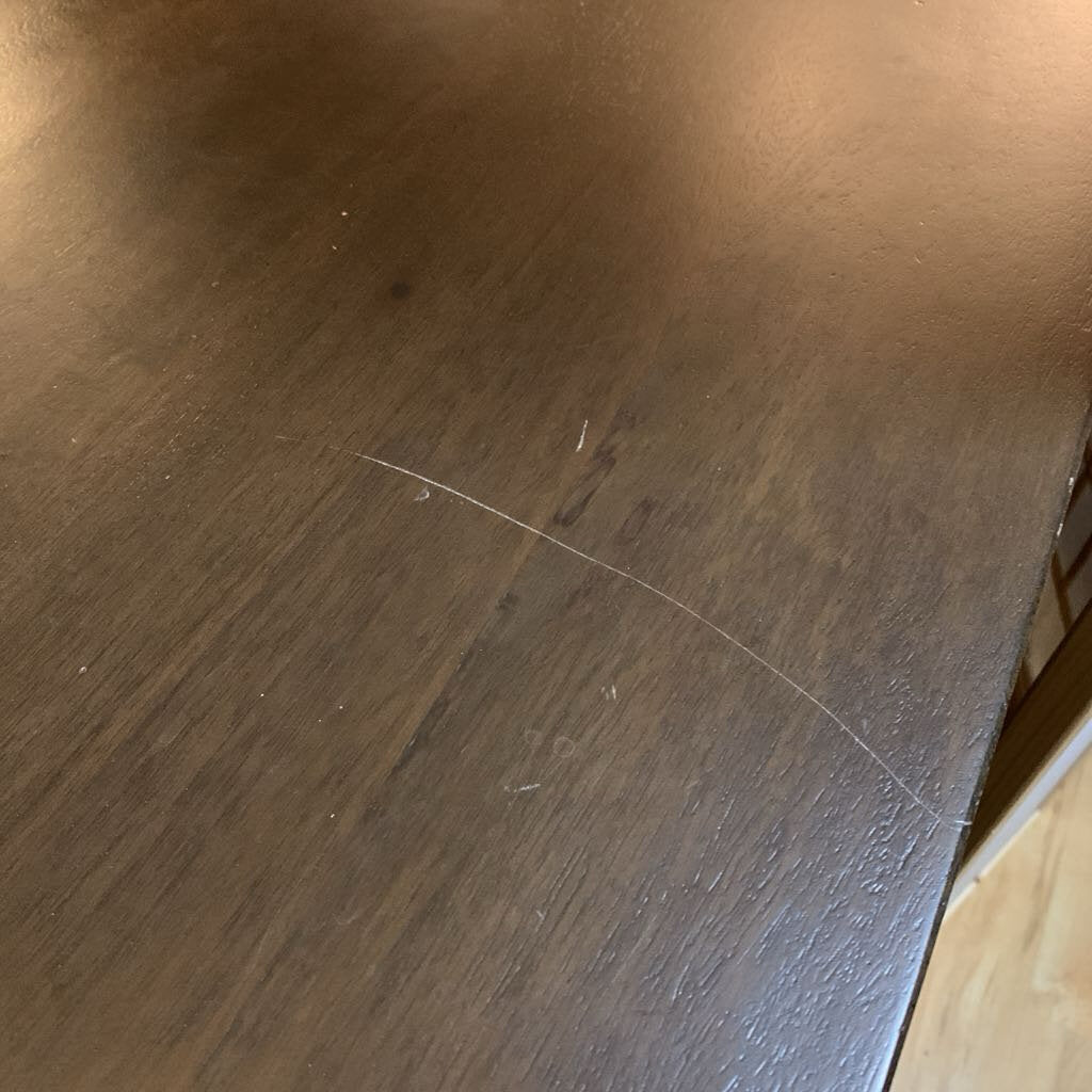 Dark wooden surface with a visible scratch