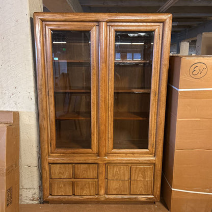 Wooden cabinet with glass doors in a storage or warehouse setting