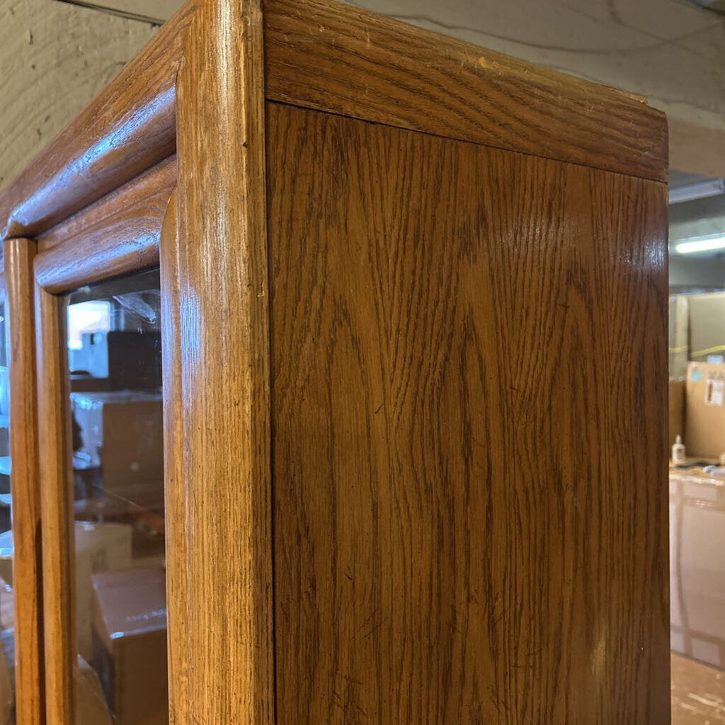 Wooden cabinet with glass doors in a warehouse setting