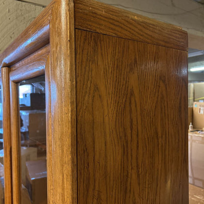 Wooden cabinet with glass doors in a warehouse setting