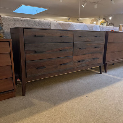 Wooden dresser with multiple drawers in a showroom setting