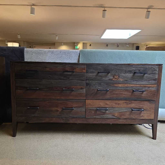 Wooden dresser with multiple drawers in a room setting