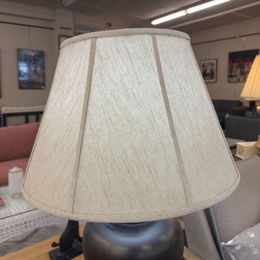 Beige lampshade on a lamp in an indoor setting