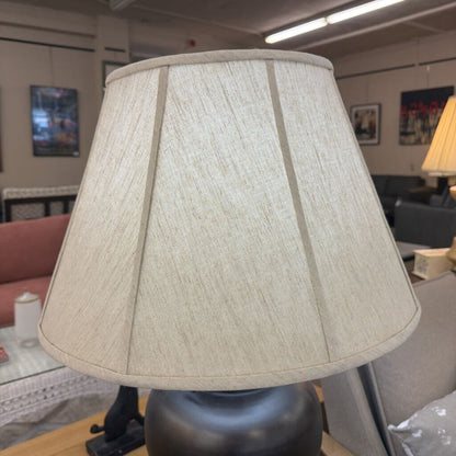 Beige lampshade on a lamp in an indoor setting