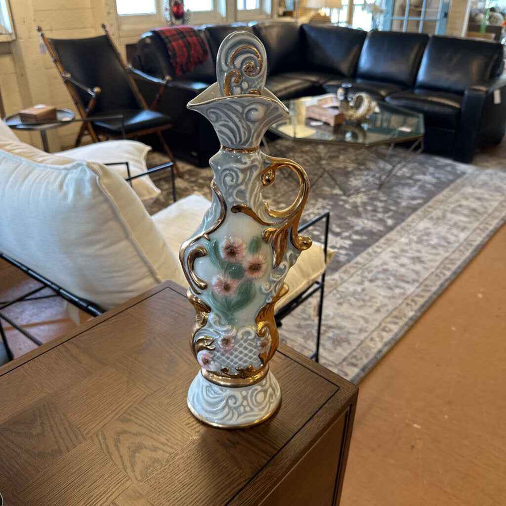 Decorative vase with floral design on a wooden table in a living room.
