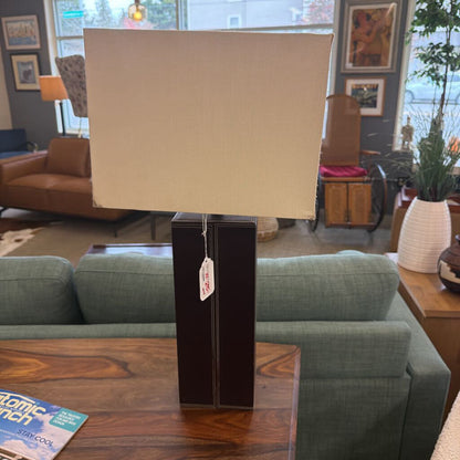 Lamp with beige shade on a wooden table in a living room setting