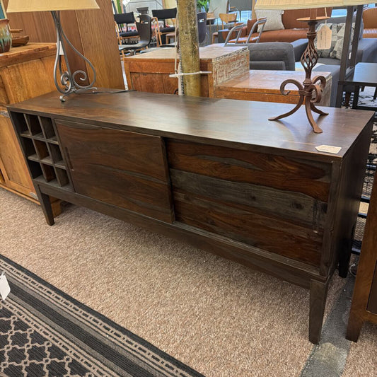 Dark wood dresser with two drawers in a furniture store setting