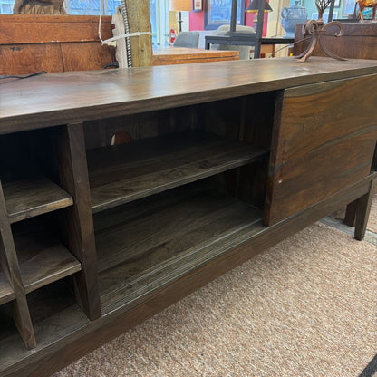 Wooden sideboard with open cabinet doors in a store setting