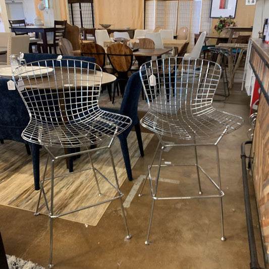 Metal bar stools in a showroom with tables and chairs in the background