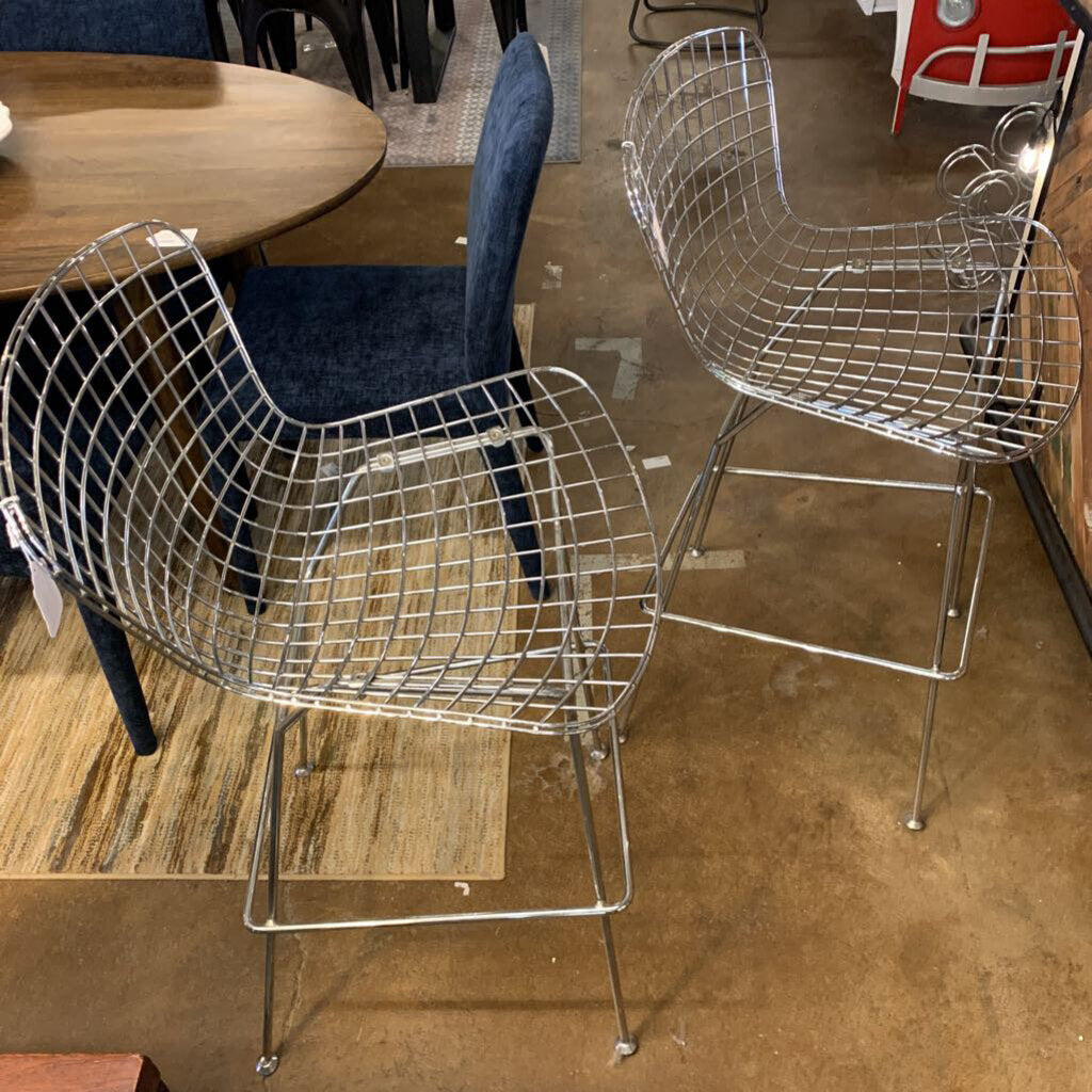 Metal wire chairs on a brown floor with a blurred background