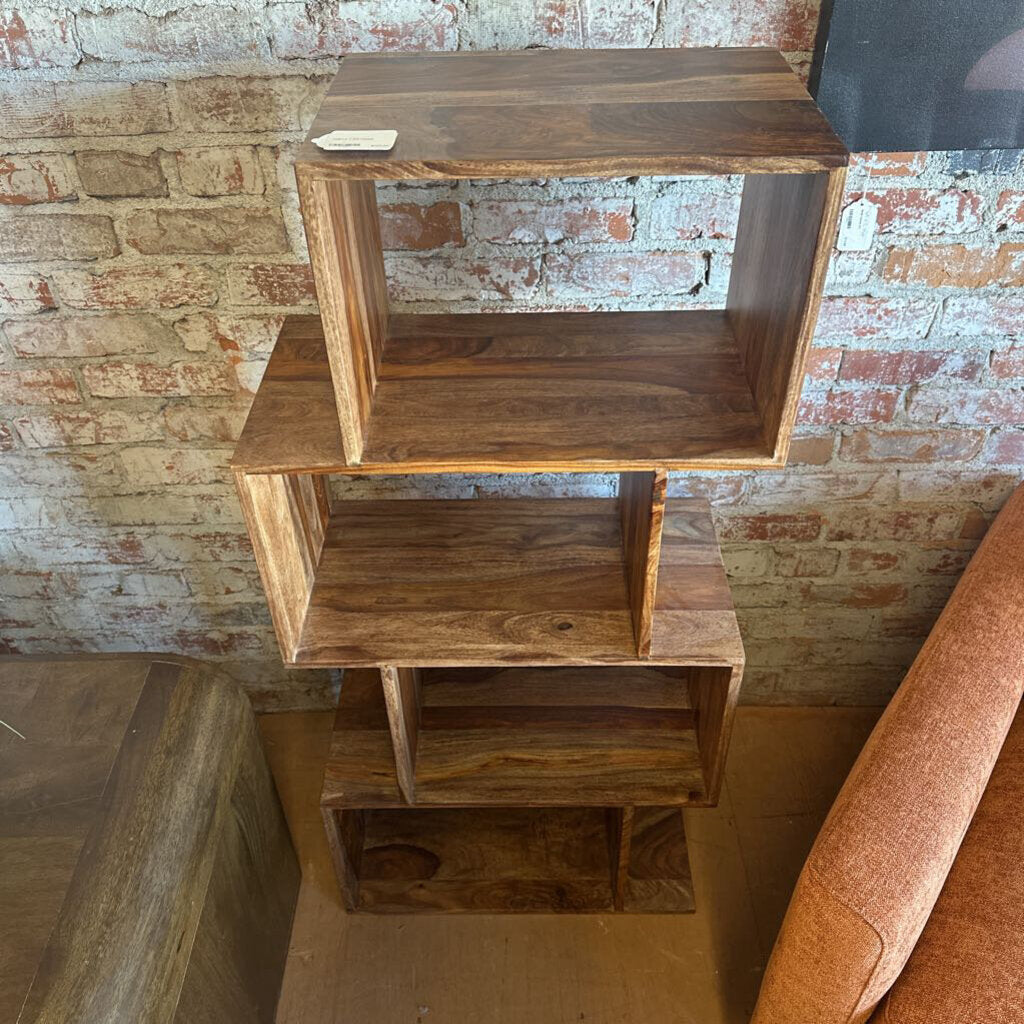 Wooden bookshelf against a brick wall