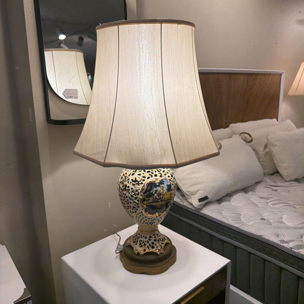 Decorative lamp with leopard print base on a nightstand next to a bed.