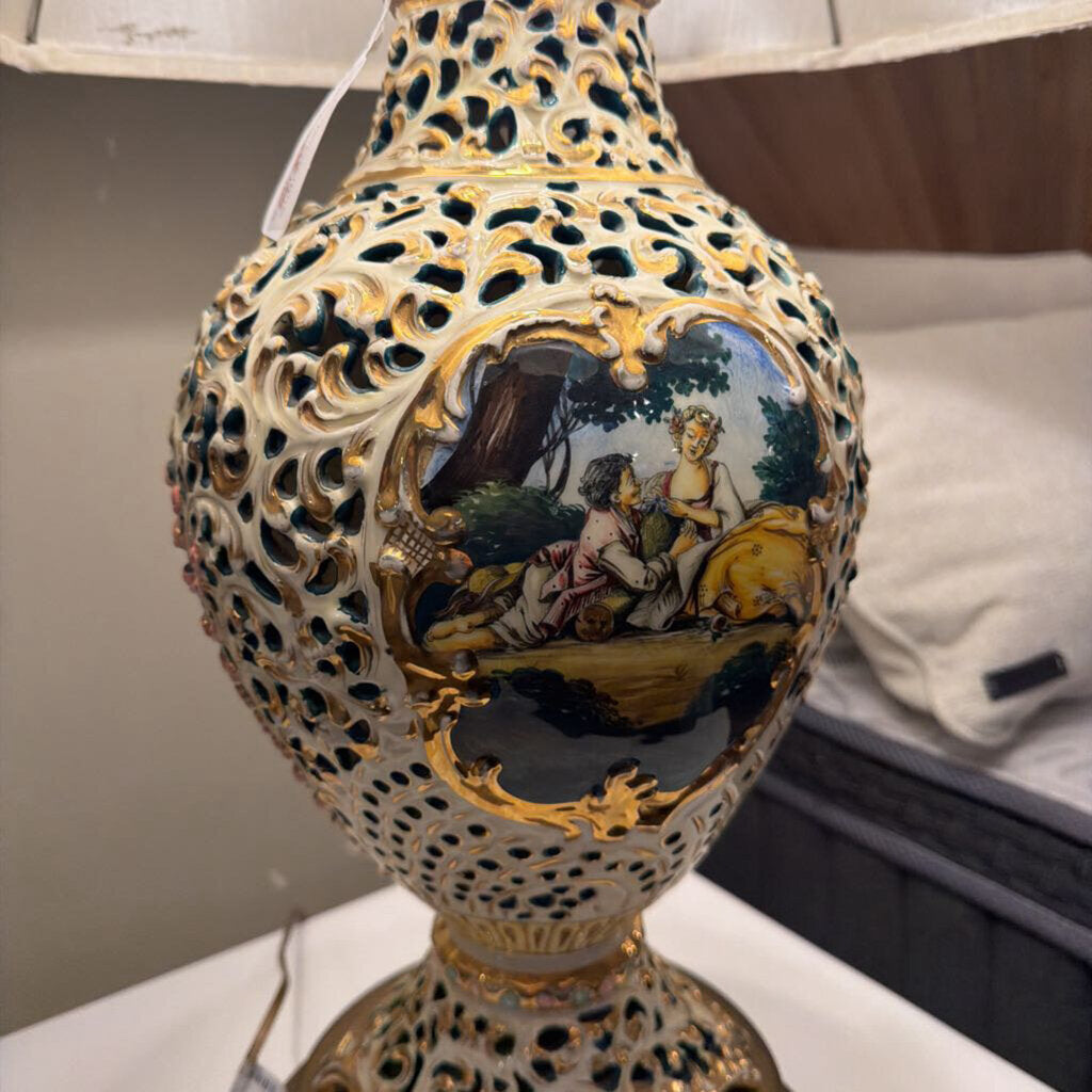 Decorative lamp with intricate design and painted scene on a white surface.