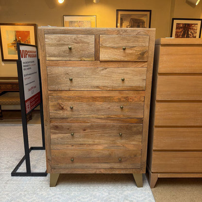 Wooden dresser with multiple drawers in a store setting