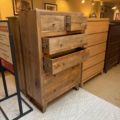Wooden dresser with multiple drawers in a store setting