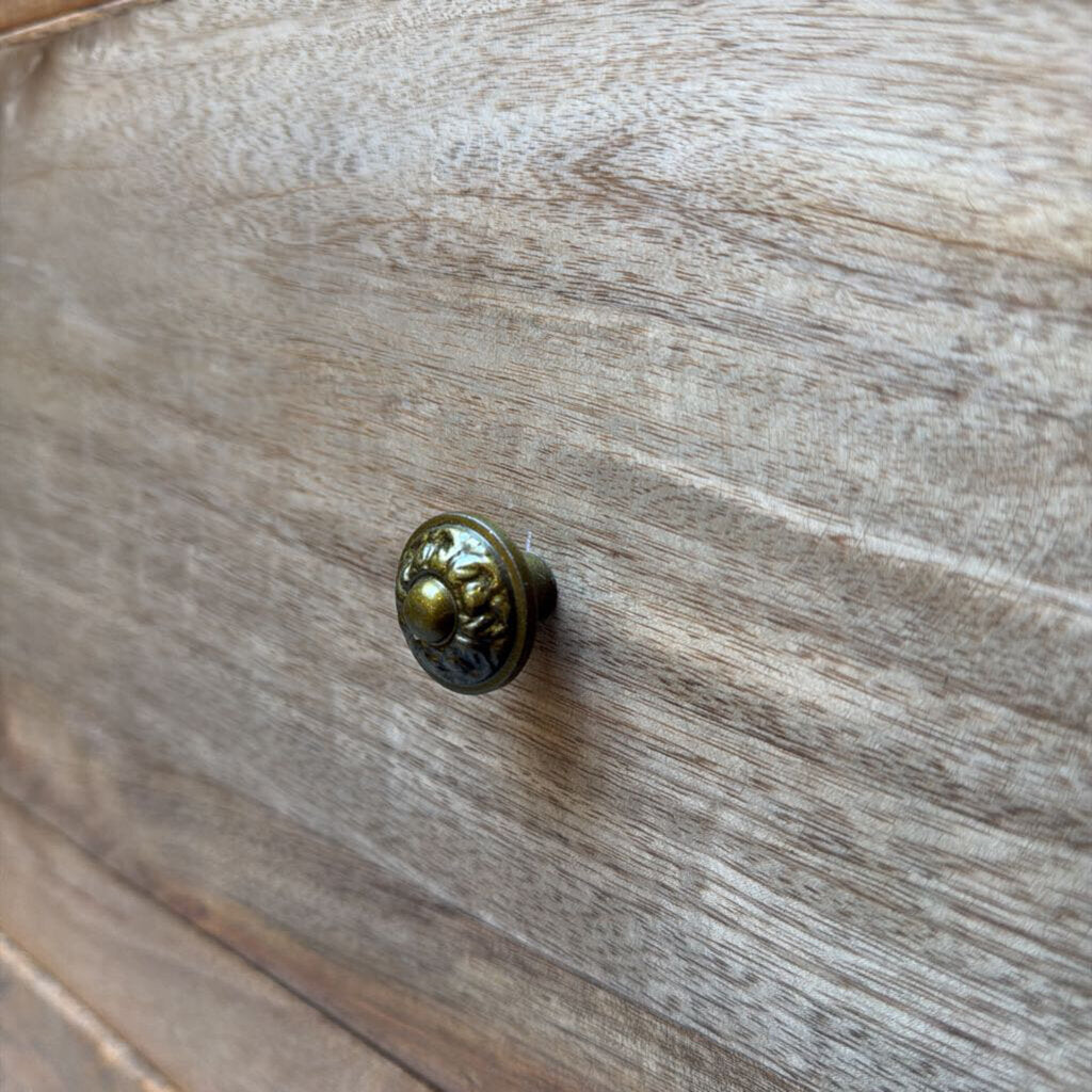 Brass cabinet knob on a wooden surface