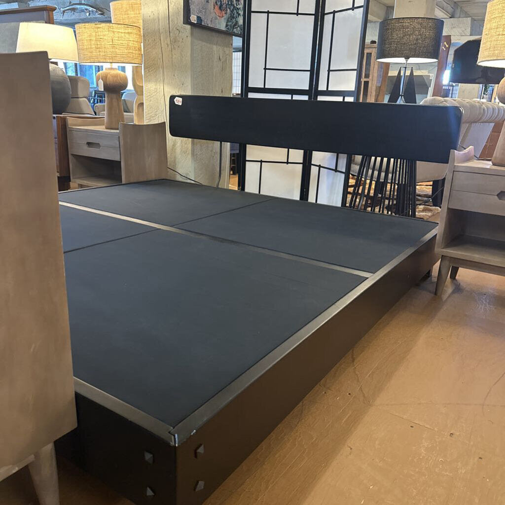 Bed frame with gray mattress in a showroom setting