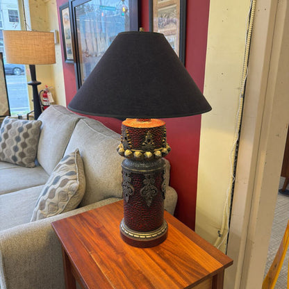 Decorative lamp with a black shade on a wooden table in a living room.