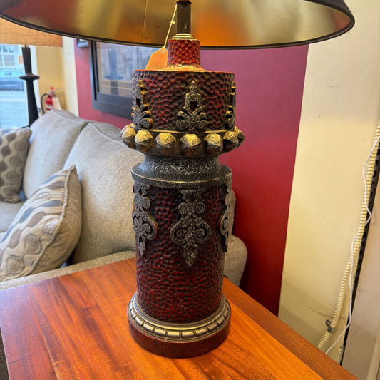 Decorative lamp on a wooden table with a couch and window in the background