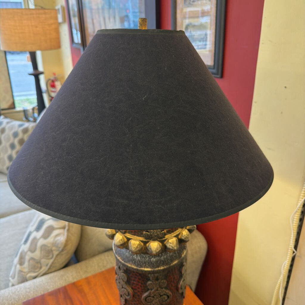 Black lampshade on a decorative lamp with a blurred indoor background