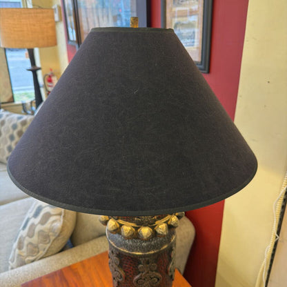 Black lampshade on a decorative lamp with a blurred indoor background