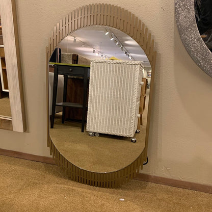 Decorative wall mirror with a unique frame design in a store setting.