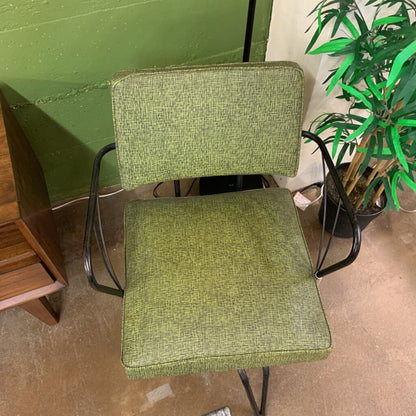 Green chair with a plant in the background