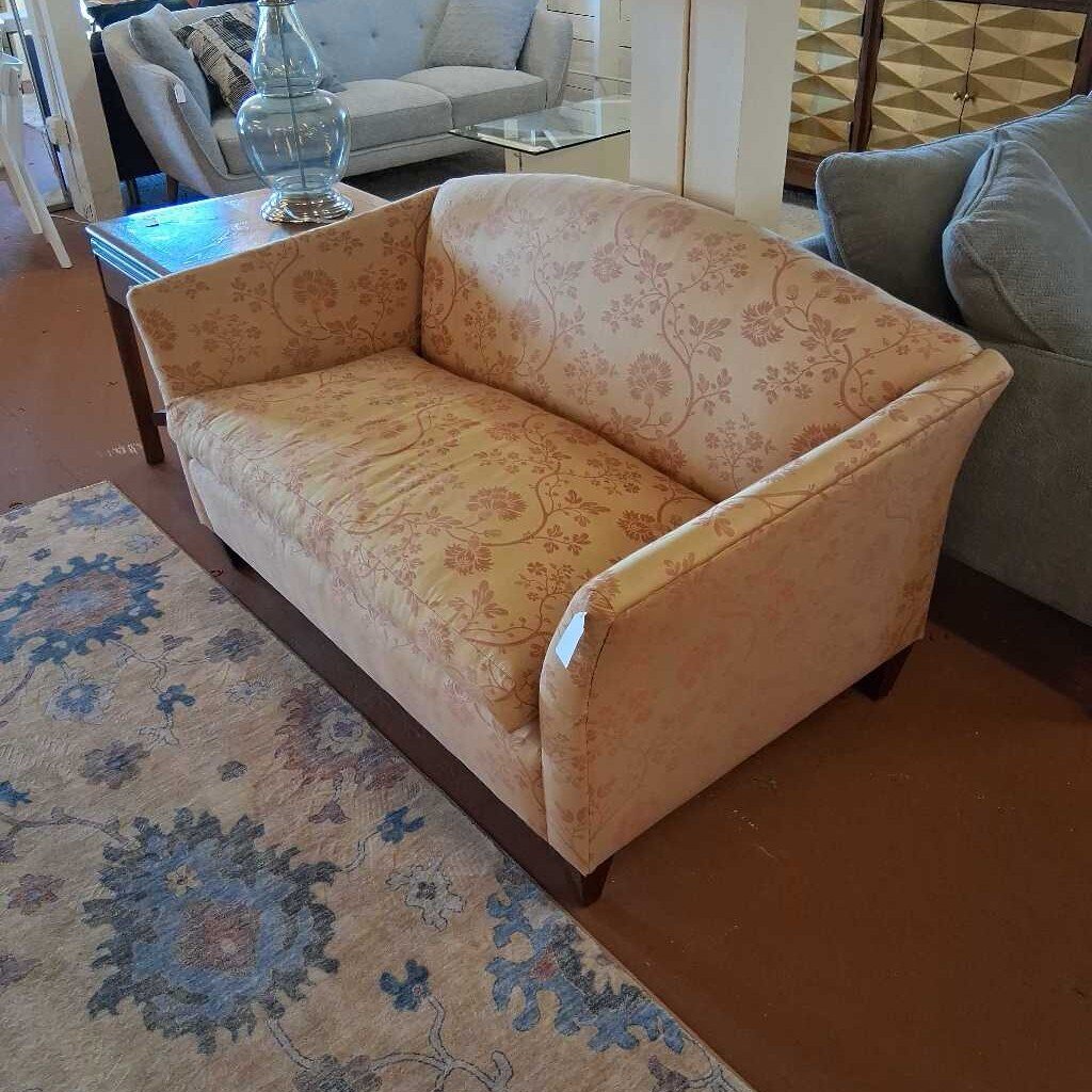 Patterned sofa in a living room setting with a rug and other furniture.