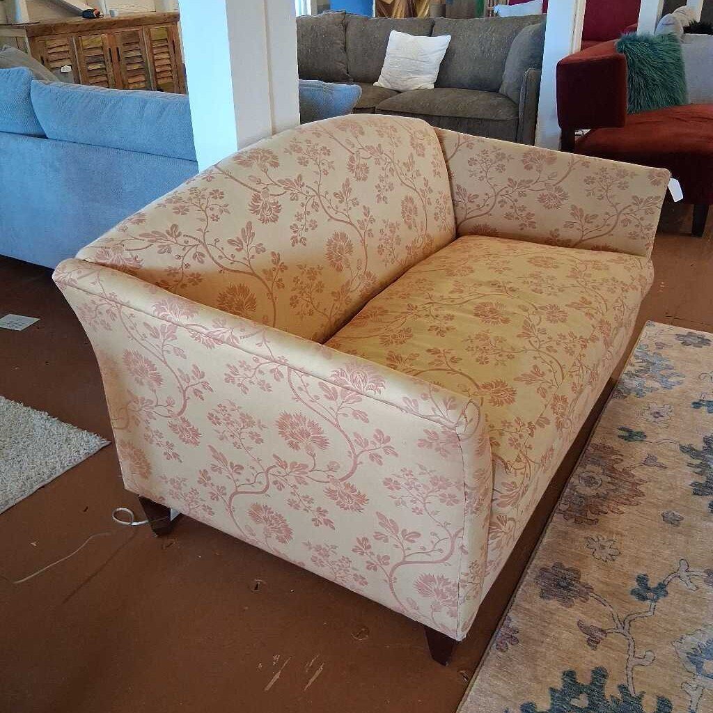 Floral-patterned sofa in a room with other furniture.