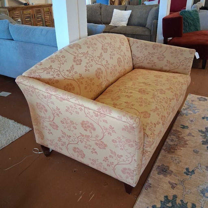 Floral-patterned sofa in a room with other furniture.