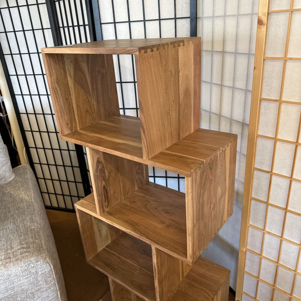 Wooden bookshelf against a decorative wall with a light background