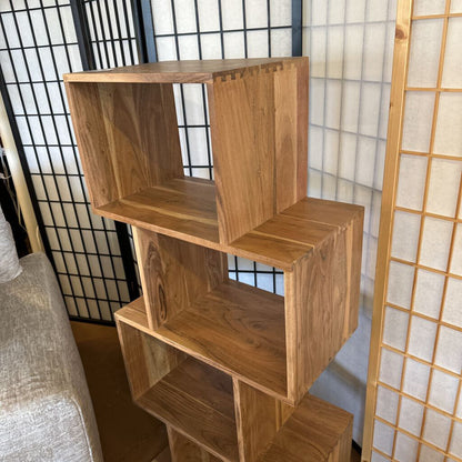 Wooden bookshelf against a decorative wall with a light background