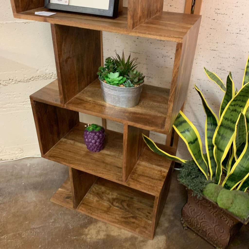 Wooden shelf with plants against a textured wall