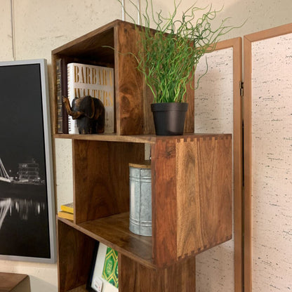 Wooden shelf with decorative items including a plant, books, and a small statue.