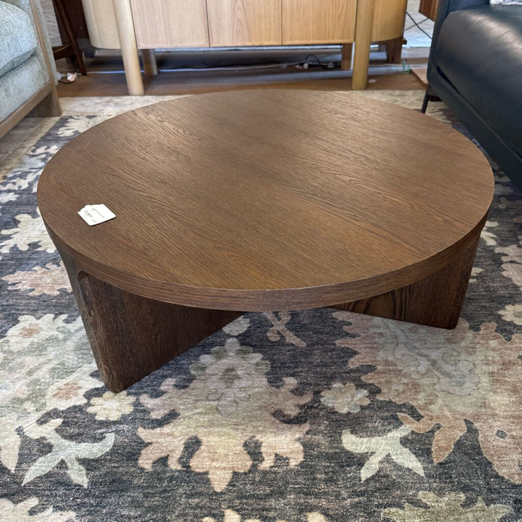 Wooden coffee table on a patterned rug with furniture in the background