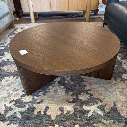 Wooden coffee table on a patterned rug with furniture in the background