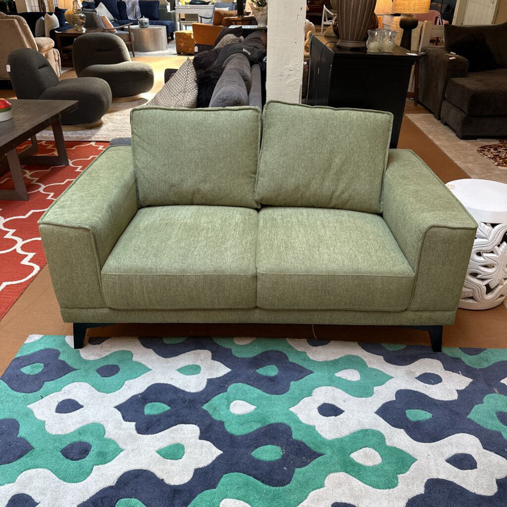 Green sofa in a room with patterned rug and furniture
