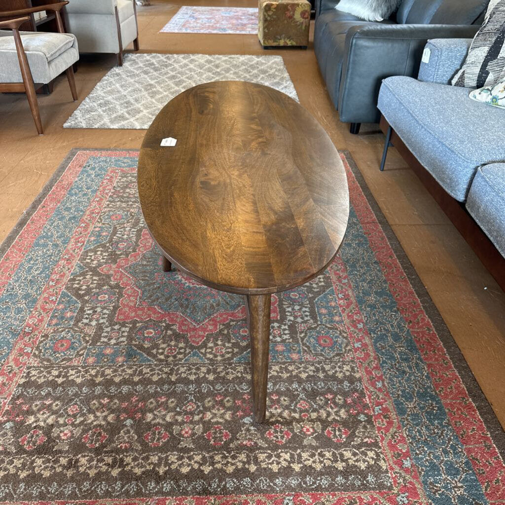 Wooden coffee table on a patterned rug in a living room setting