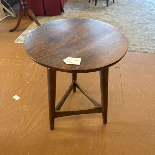 Round wooden table with a tag on a wooden floor
