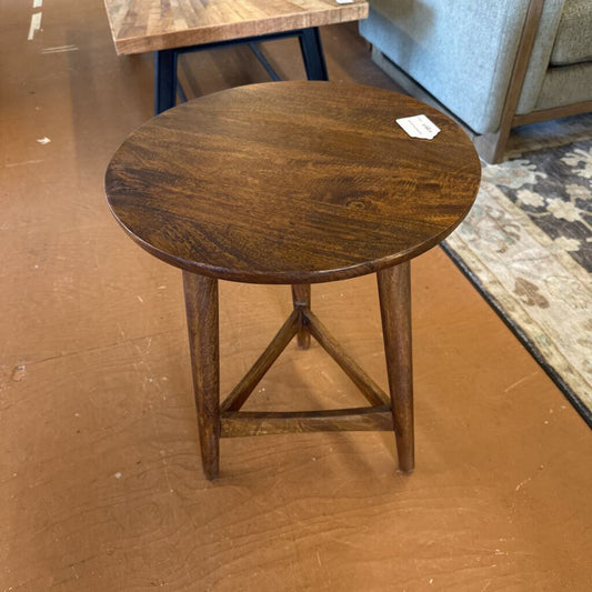 Wooden side table on a brown floor with a blurred background