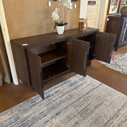 Dark wood sideboard with open doors on a carpeted floor