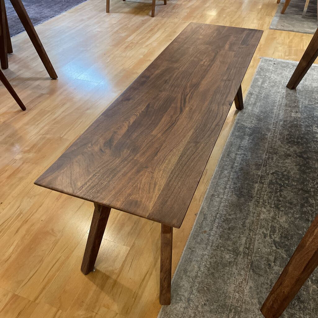 Wooden dining table on a wooden floor with a rug underneath