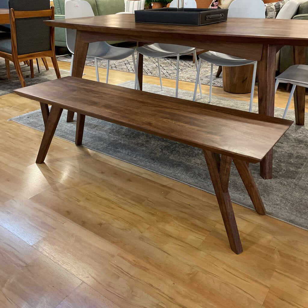 Wooden bench in a room with a wooden floor and furniture.