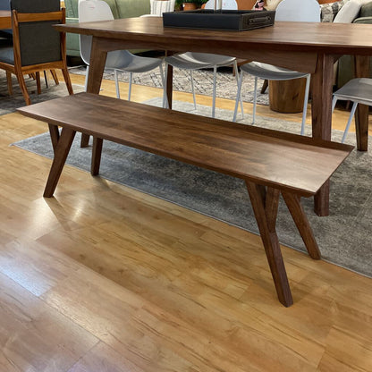 Wooden bench in a room with a wooden floor and furniture.