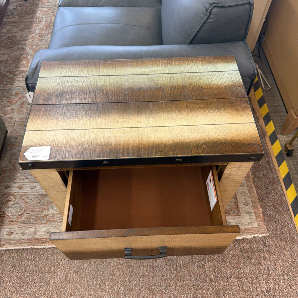 Wooden side table with open drawer in front of a gray sofa